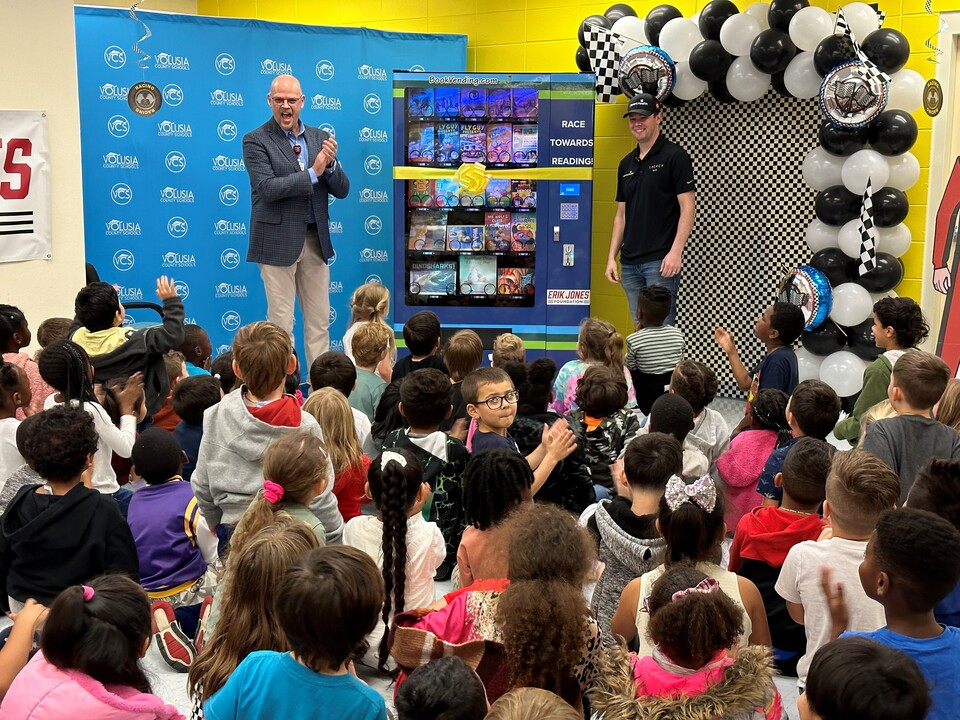 NASCAR Driver Reads to Children and Delivers a "Bookworm" Vending Machine to Volusia Elementary School